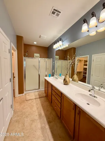 a spacious bathroom with a double vanity sink mirror and shower
