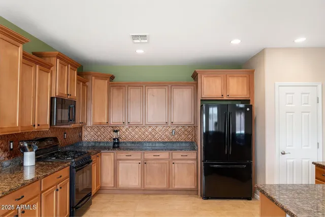 a kitchen with granite countertop a refrigerator and a sink