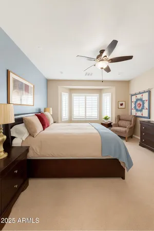 a spacious bedroom with a bed a window and couch