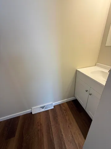 a view of a room with wooden floor and white walls