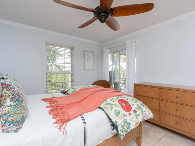 a bedroom with a bed a dresser and a window