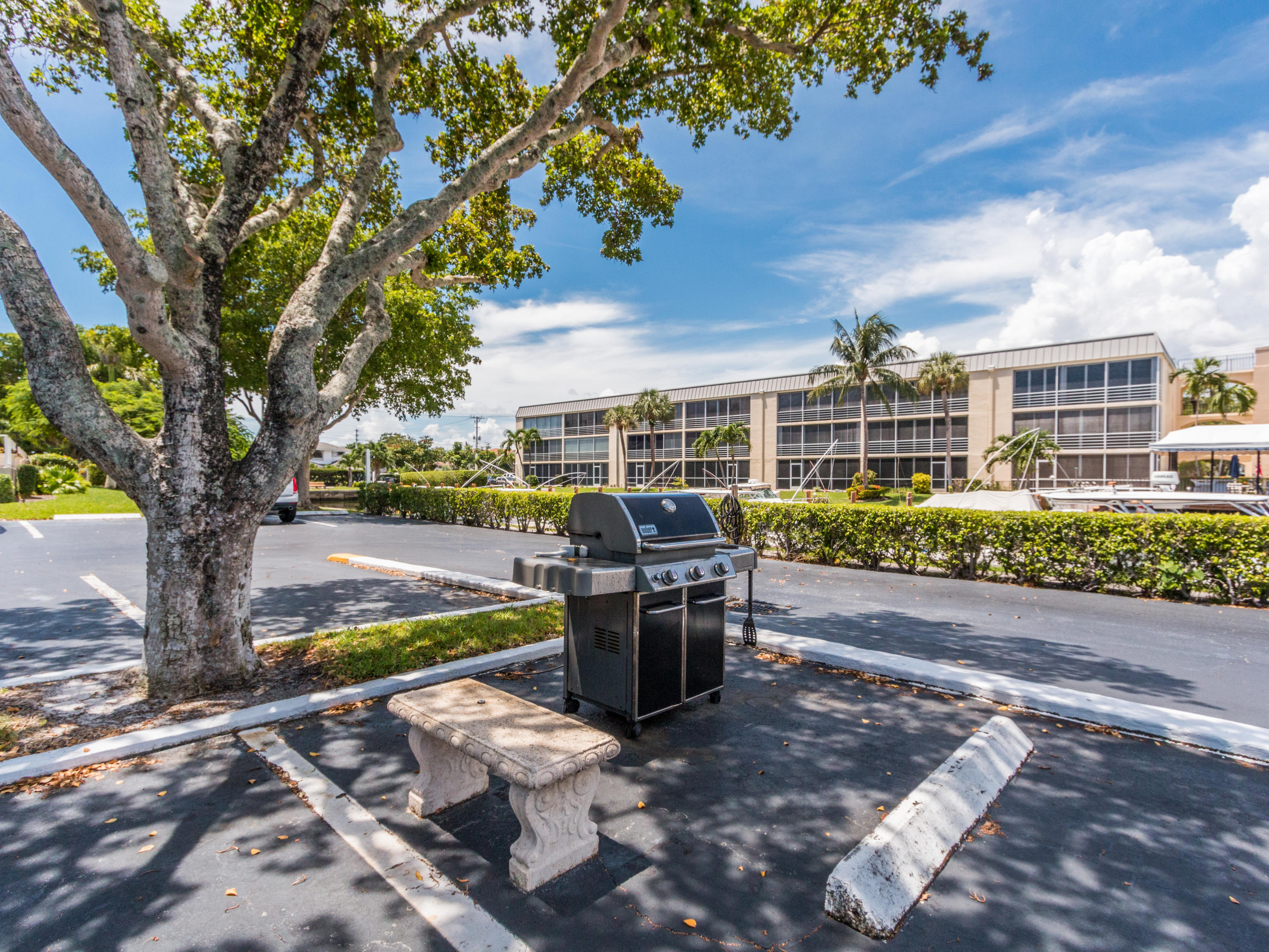 765 Jeffery Street, Unit 1301 Boca Raton, FL 33487 - Photo 29 of 31 a view of a patio with table and chairs potted plants and large tree