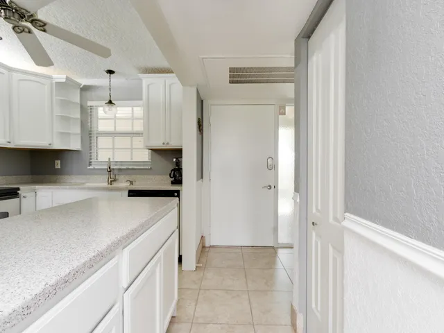 a kitchen with granite countertop a sink dishwasher a refrigerator and a stove