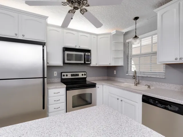 a kitchen with stainless steel appliances a refrigerator sink and microwave