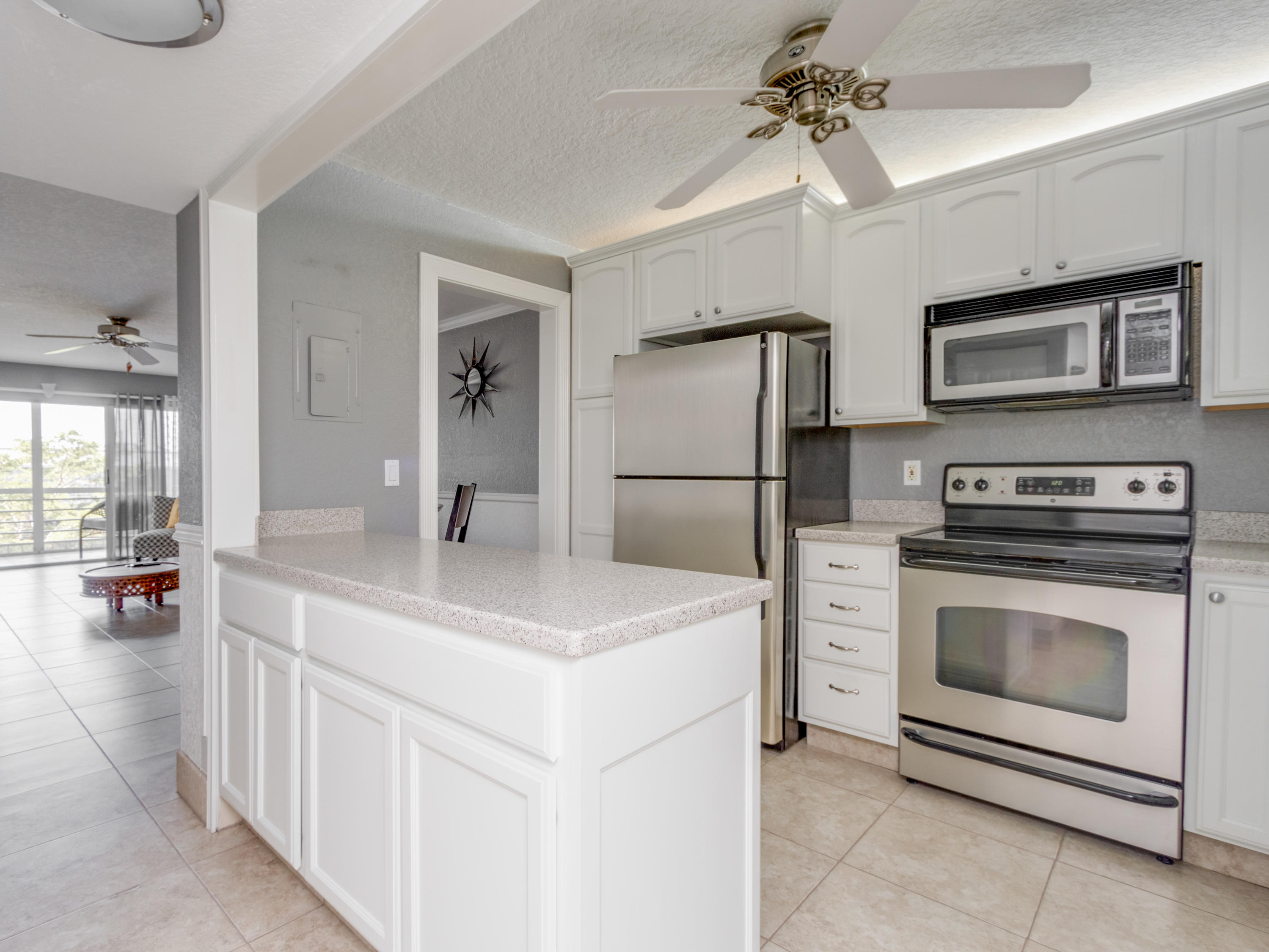 765 Jeffery Street, Unit 1301 Boca Raton, FL 33487 - Photo 5 of 31 a kitchen with kitchen island a stove a sink and a refrigerator
