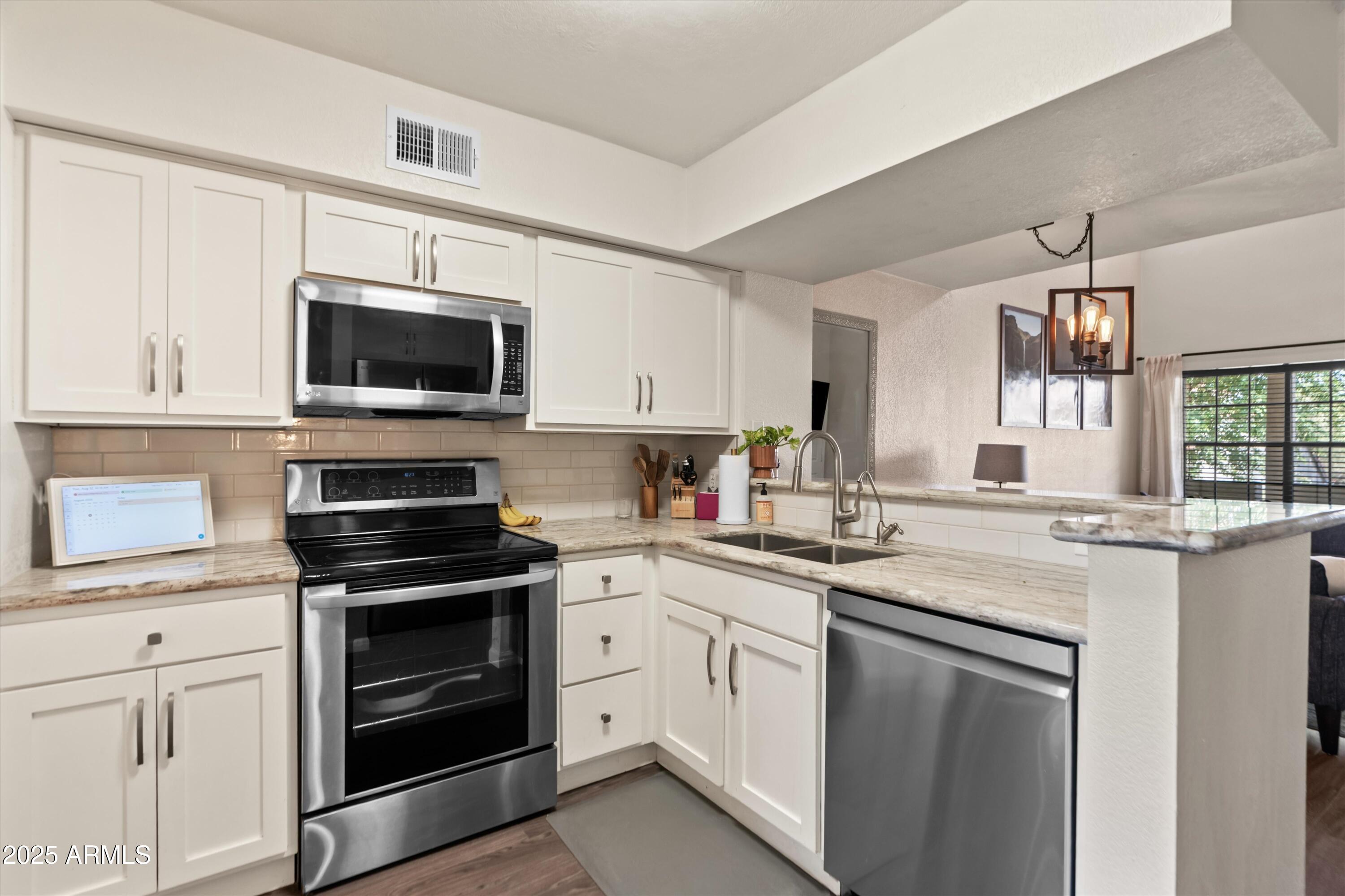 2333 East Southern Avenue, Unit 2067 Tempe, AZ 85282 - Photo 4 of 32 a kitchen with cabinets stainless steel appliances a sink and a counter space