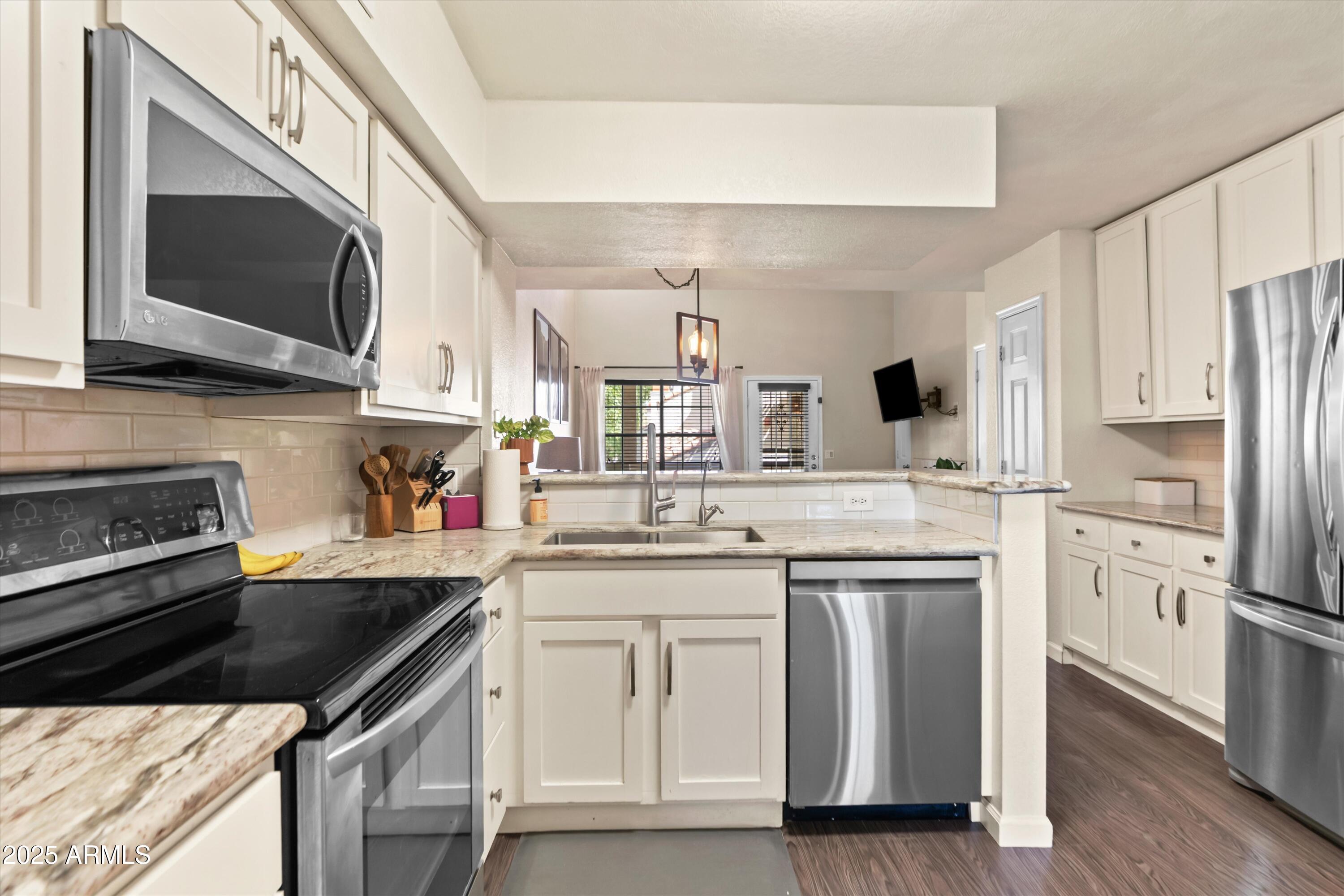 2333 East Southern Avenue, Unit 2067 Tempe, AZ 85282 - Photo 6 of 32 a kitchen with stainless steel appliances a stove microwave and a sink