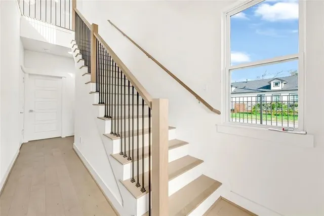 a view of staircase with lots of frames on wall and windows