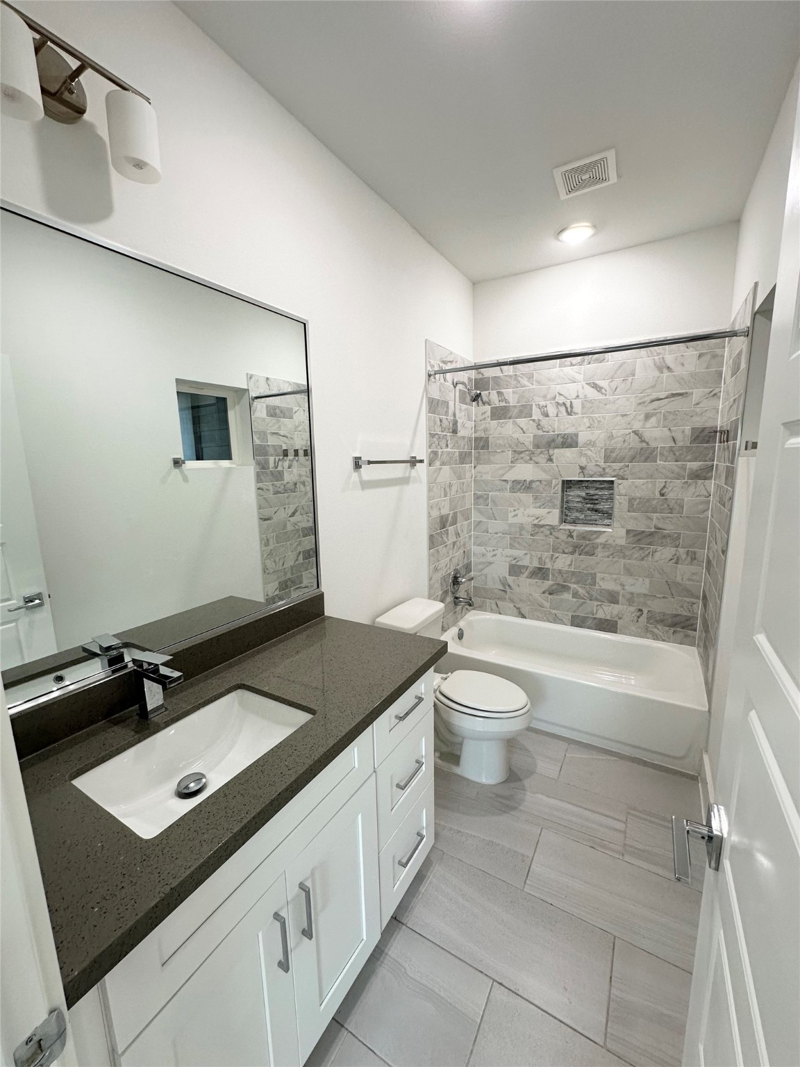 4623 Cochran Street Houston, TX 77009 - Photo 5 of 12 a bathroom with a granite countertop sink toilet a bathtub and shower