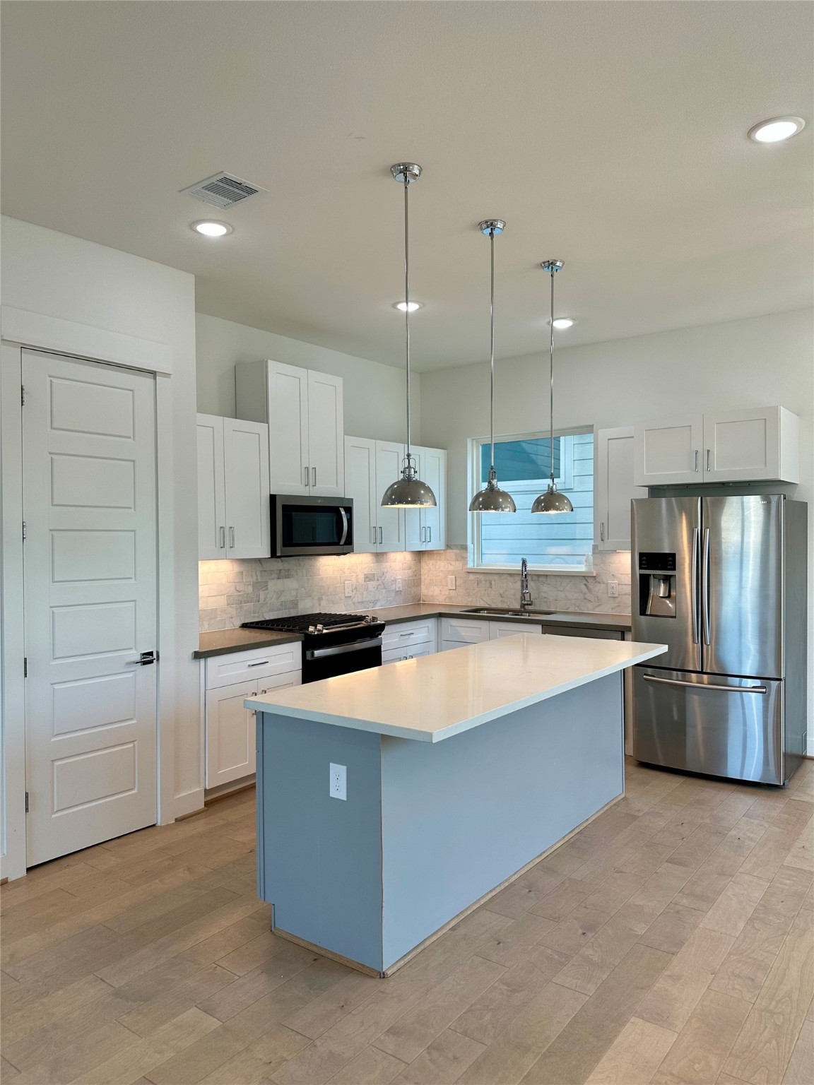 4623 Cochran Street Houston, TX 77009 - Photo 8 of 12 a large kitchen with stainless steel appliances granite countertop a sink a stove a refrigerator and island