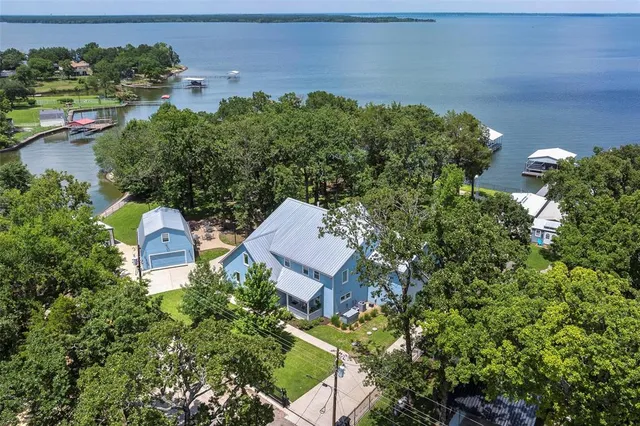 an aerial view of a house with a garden and lake view