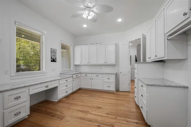 a view of kitchen and empty room with wooden floor