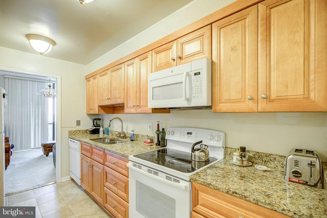 a view of a kitchen with granite countertop a sink and cabinets