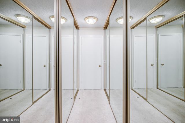 a spacious bedroom with a bed and glass walk in closet