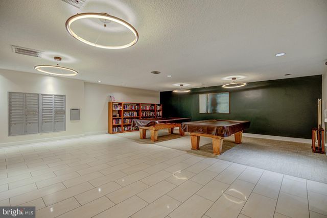 a kitchen with stainless steel appliances granite countertop a stove a sink a dining table and chairs with wooden floor