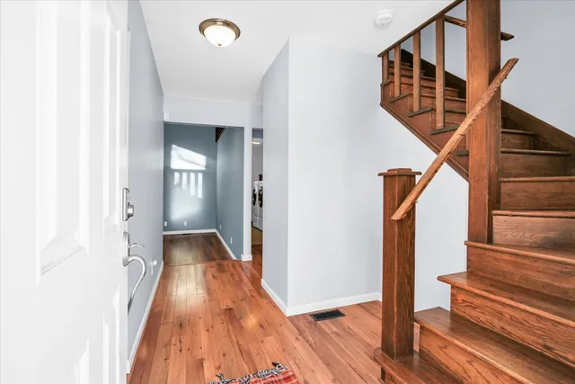 a view of a hallway with wooden floor and a living room