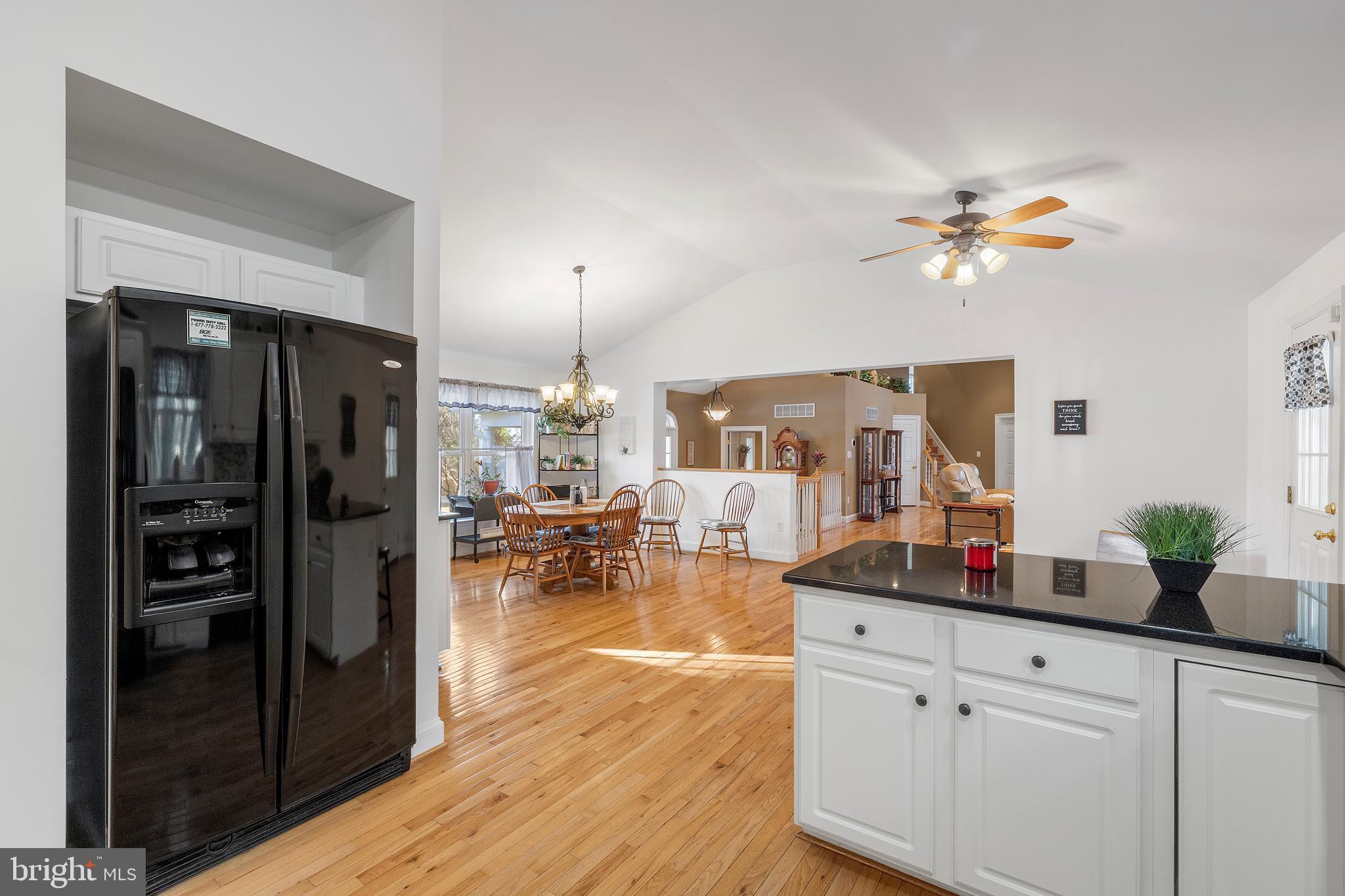 518 North Old Hammonds Ferry Road Linthicum Heights, MD 21090 - Photo 22 of 57 a kitchen with stainless steel appliances granite countertop a refrigerator a stove and a dining table with wooden floor