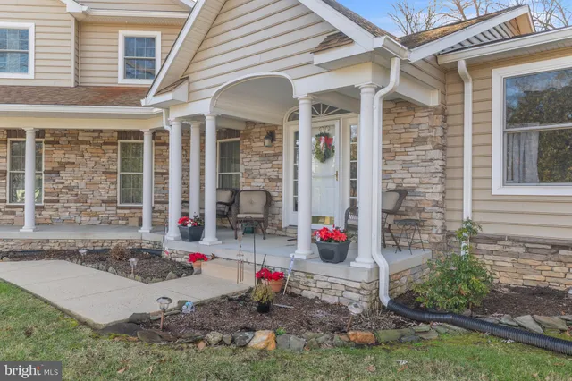 a view of a hallway to a livingroom with wooden floor and stairs