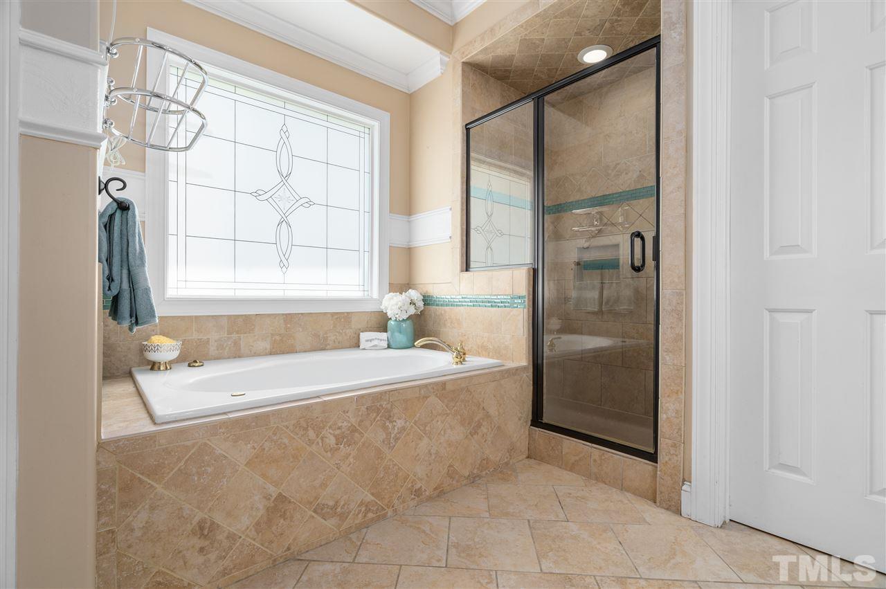9408 Gabe Court Raleigh, NC 27613 - Photo 16 of 30 a spacious bathroom with a tub shower and windows