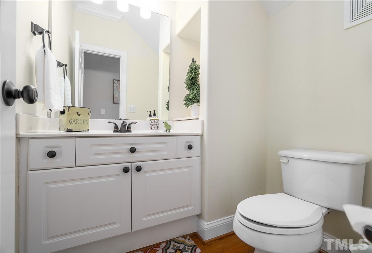 9408 Gabe Court Raleigh, NC 27613 - Photo 18 of 30 a bathroom with a toilet sink vanity and mirror