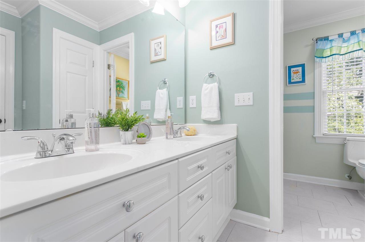 9408 Gabe Court Raleigh, NC 27613 - Photo 20 of 30 a bathroom with double vanity sink a window and a mirror