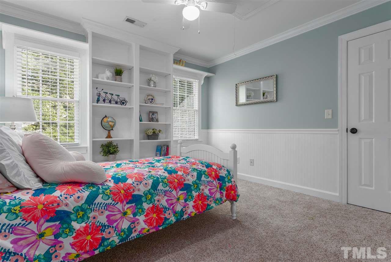 9408 Gabe Court Raleigh, NC 27613 - Photo 21 of 30 a bedroom with a bed and a chandelier
