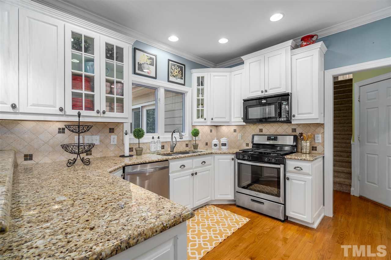 9408 Gabe Court Raleigh, NC 27613 - Photo 9 of 30 a kitchen with stainless steel appliances granite countertop a stove a sink and a microwave