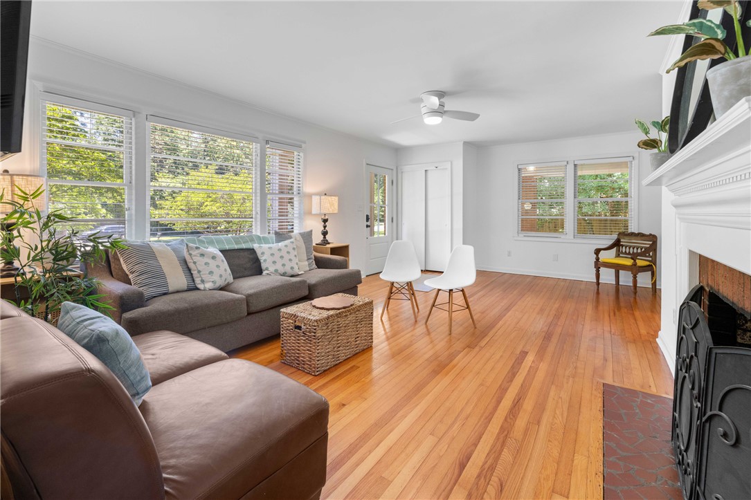 207 Brook Street Clemson, SC 29631 - Photo 11 of 39 Luminous living space featuring polished hardwood floors and a cozy fireplace, perfect for gatherings.