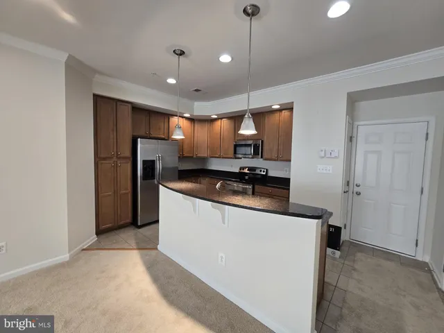 a kitchen with stainless steel appliances granite countertop a refrigerator a sink and a stove