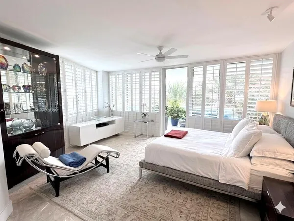 a bedroom with a bed and large windows