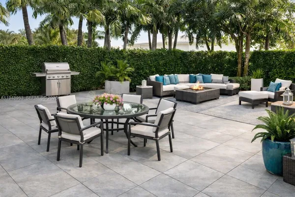 a view of a patio with a dining table and chairs with a fire pit