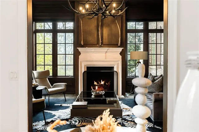 a living room with furniture a chandelier and a fireplace