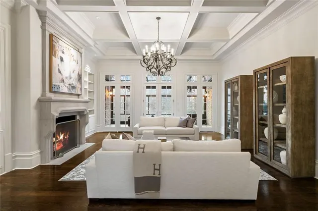 a living room with furniture a chandelier and a fireplace