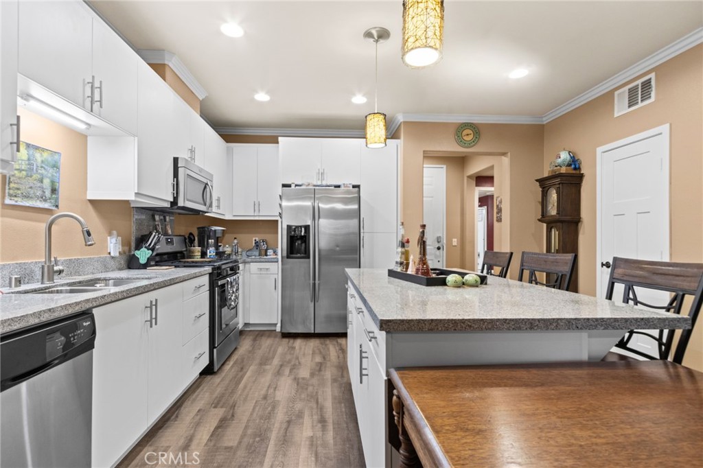 431 South Anaheim Way, Unit 5 Orange, CA 92868 - Photo 11 of 35 a large kitchen with kitchen island a large counter space a sink appliances and cabinets