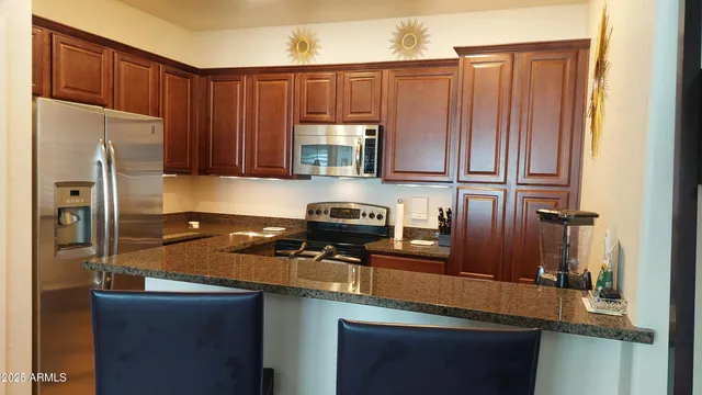 a kitchen with a table chairs refrigerator and microwave