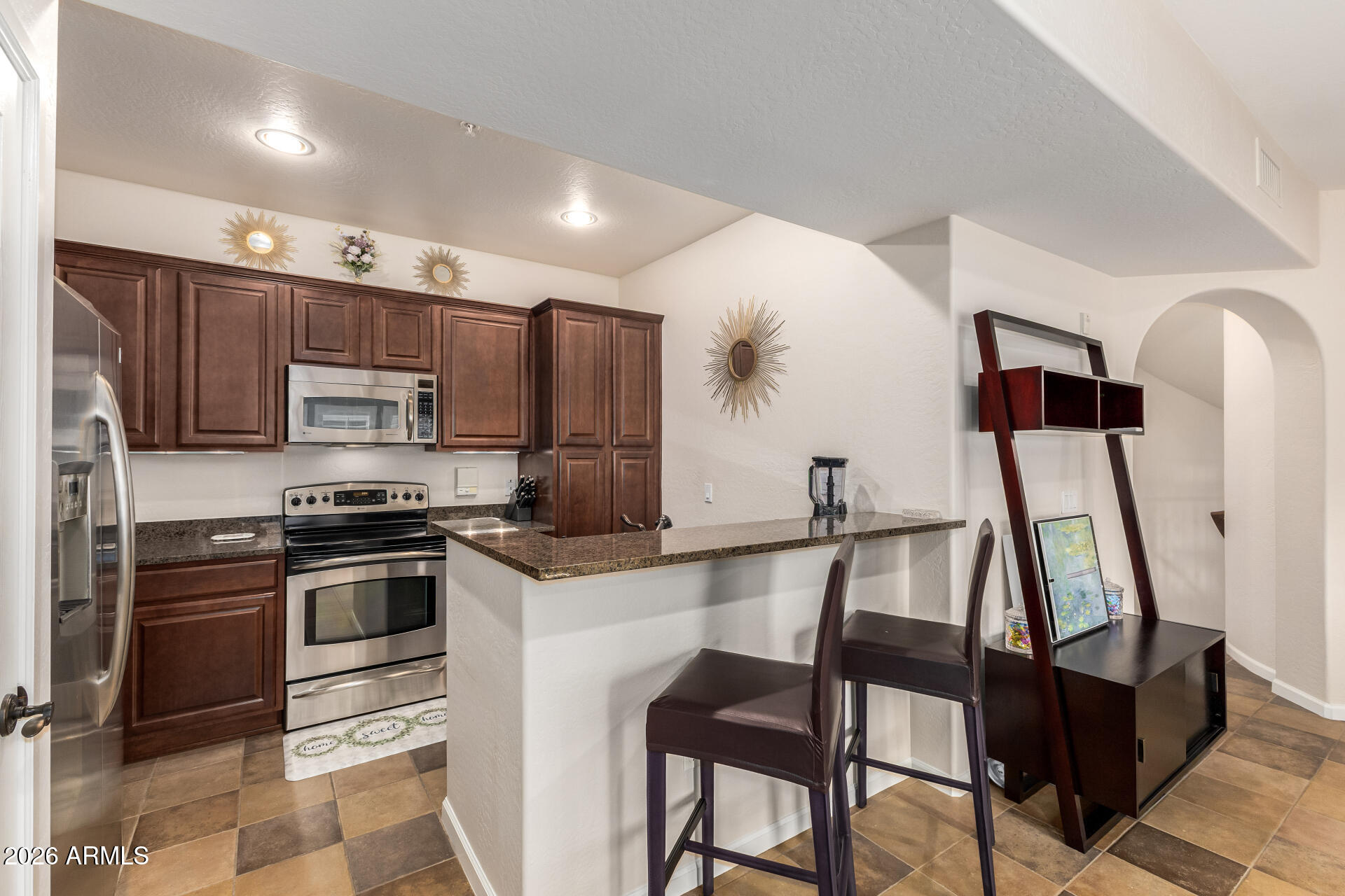 3935 East Rough Rider Road, Unit 1197 Phoenix, AZ 85050 - Photo 15 of 51 a kitchen with stainless steel appliances granite countertop a stove a sink and a refrigerator