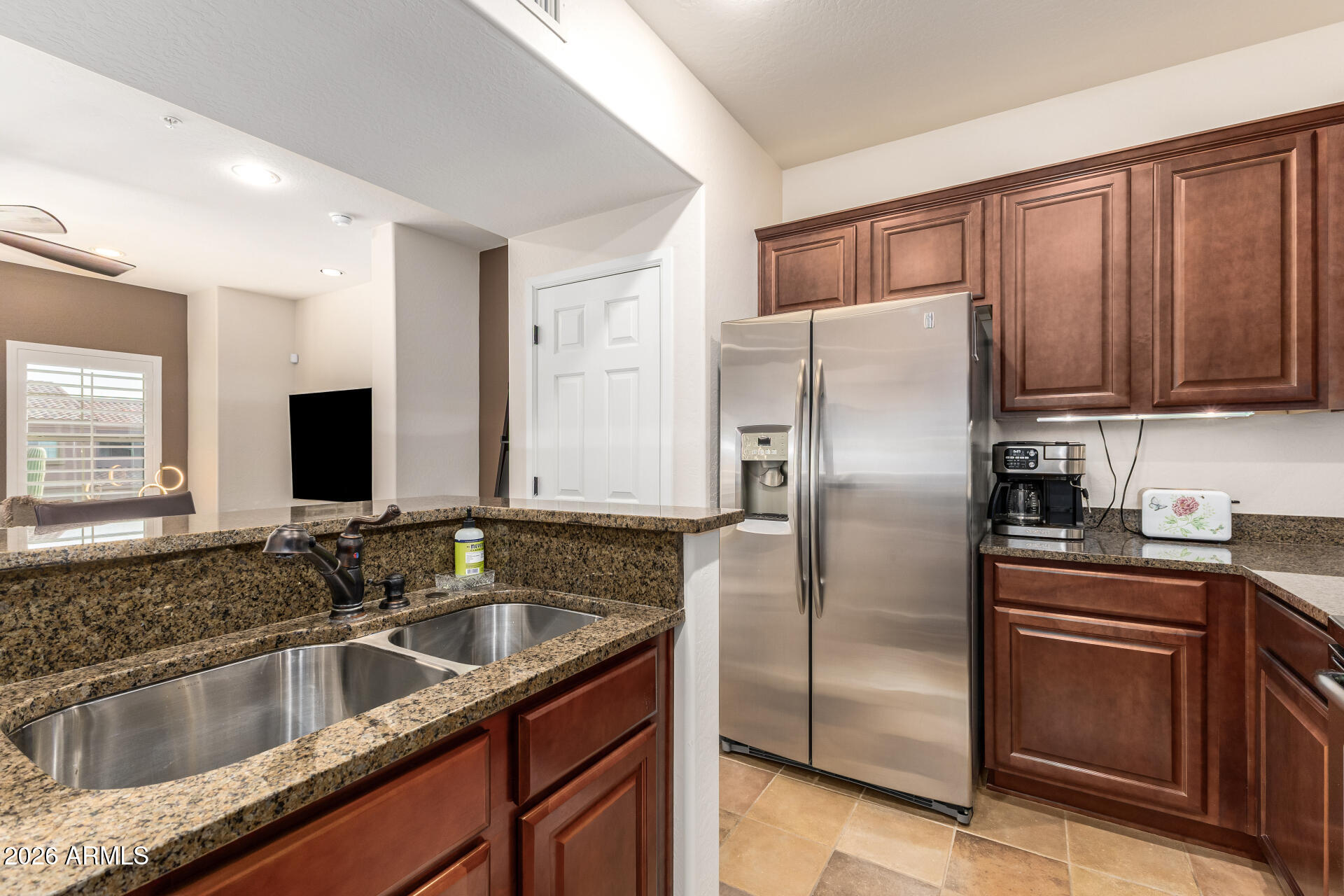 3935 East Rough Rider Road, Unit 1197 Phoenix, AZ 85050 - Photo 18 of 51 a kitchen with kitchen island granite countertop a sink refrigerator and microwave
