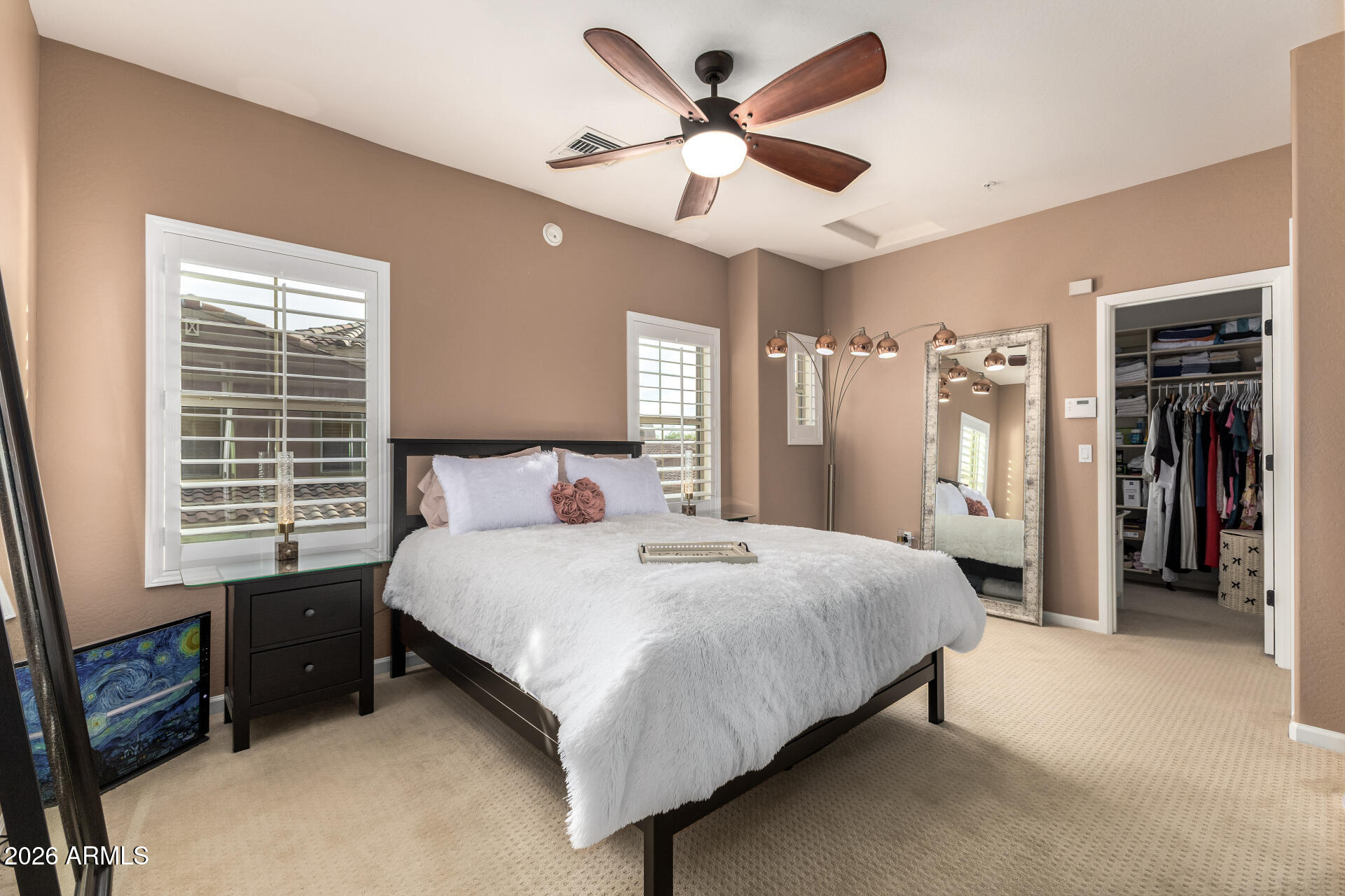 3935 East Rough Rider Road, Unit 1197 Phoenix, AZ 85050 - Photo 26 of 51 a spacious bedroom with a bed and a ceiling fan