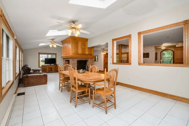 a dining room with furniture a floor to ceiling window and a fireplace