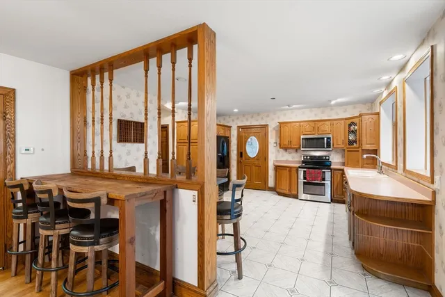 a open kitchen with stainless steel appliances kitchen island granite countertop a table and chairs in it