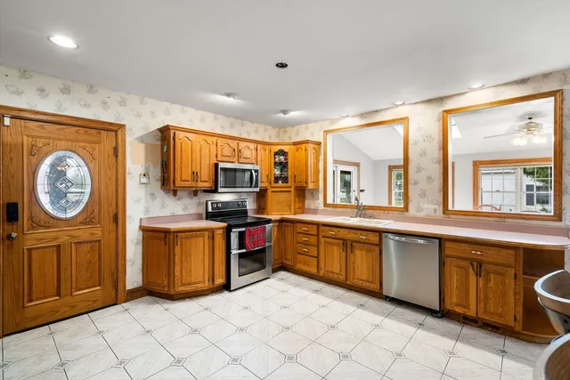 a large kitchen with stainless steel appliances granite countertop a large stove top oven a sink and dishwasher