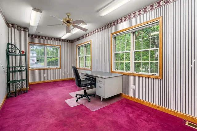 a view of a workspace with furniture and a window