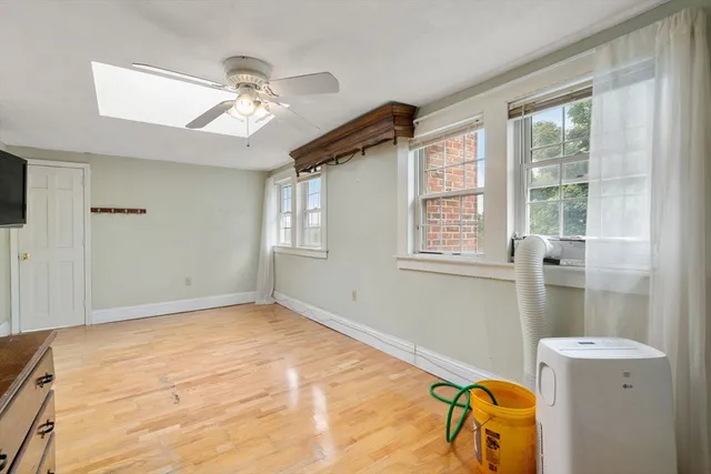 a view of a livingroom with a window and chandelier fan