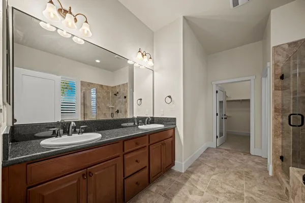 a spacious bathroom with a double vanity sink mirror double and shower