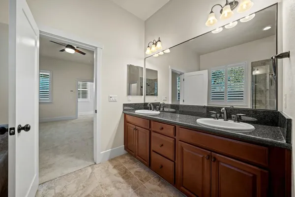 a spacious bathroom with a double vanity sink a mirror and a shower