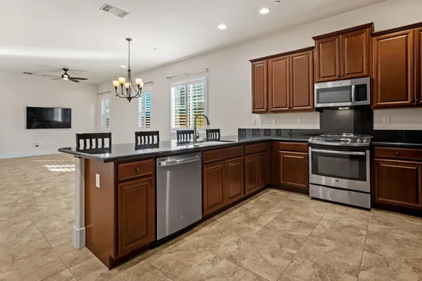 a kitchen with stainless steel appliances granite countertop a sink stove and microwave
