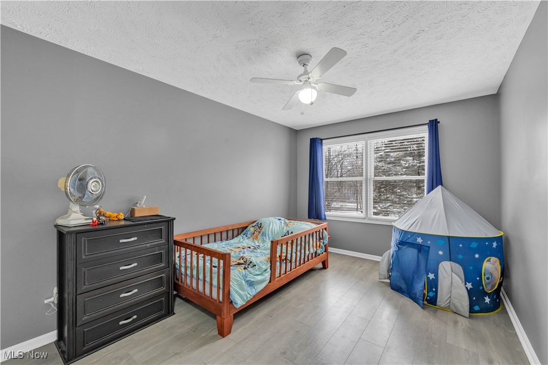 1033 Parsons Road Grafton, OH 44044 - Photo 13 of 25 Bedroom featuring ceiling fan, a textured ceiling, and light wood-style floors