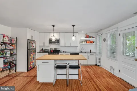 a room with stainless steel appliances hardwood floor and large windows