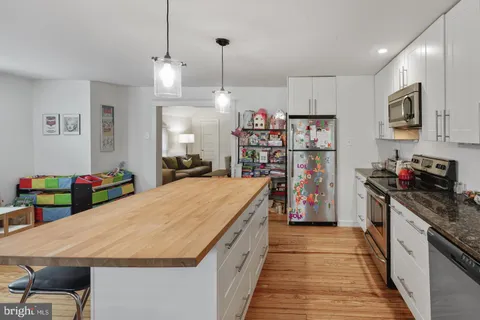 a kitchen with kitchen island a stove and a wooden floors