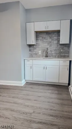 a view of a kitchen with cabinets and wooden floor